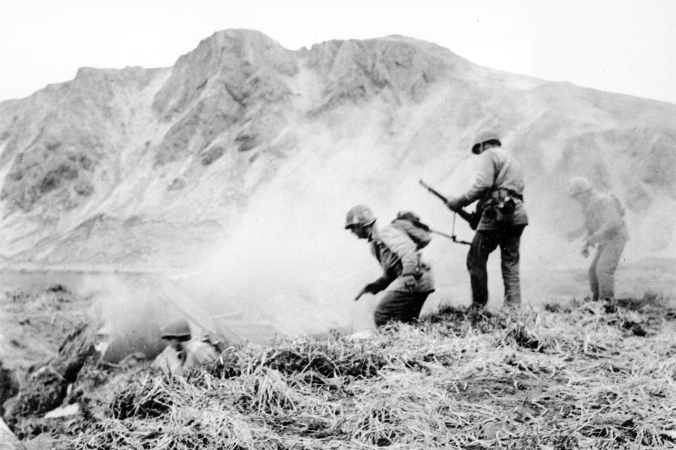 FILE - A U.S. squad armed with guns and hand grenades closes in on Japanese holdouts entrenched in dugouts during World War II on Attu Island, Alaska, in June 1943. Gregory Golodoff, who was 3 years old when his remote Alaska island was captured by Japanese troops and who became the last survivor among its 41 residents sent to Japan as prisoners, has died. The island of Attu in the Aleutian chain was one of just a few U.S. territories taken by enemy forces during the war, and the American effort to reclaim it amid frigid rain, dense fog and hurricane-force winds was the only battle of the war fought on North American soil. (U.S. Army via AP, File)