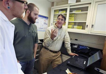 University of New England biomedical researcher Ian Meng (R) speaks with graduate students Mike Anderson (L) and Neal Mecum as he works in his laboratory in Biddeford, Maine September 26, 2013. REUTERS/Joel Page