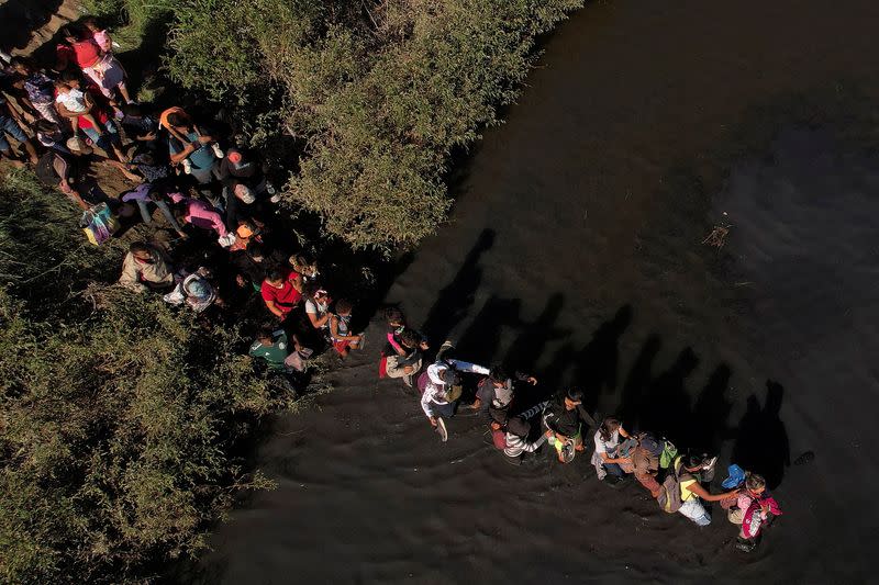 Migrants cross the Rio Bravo river