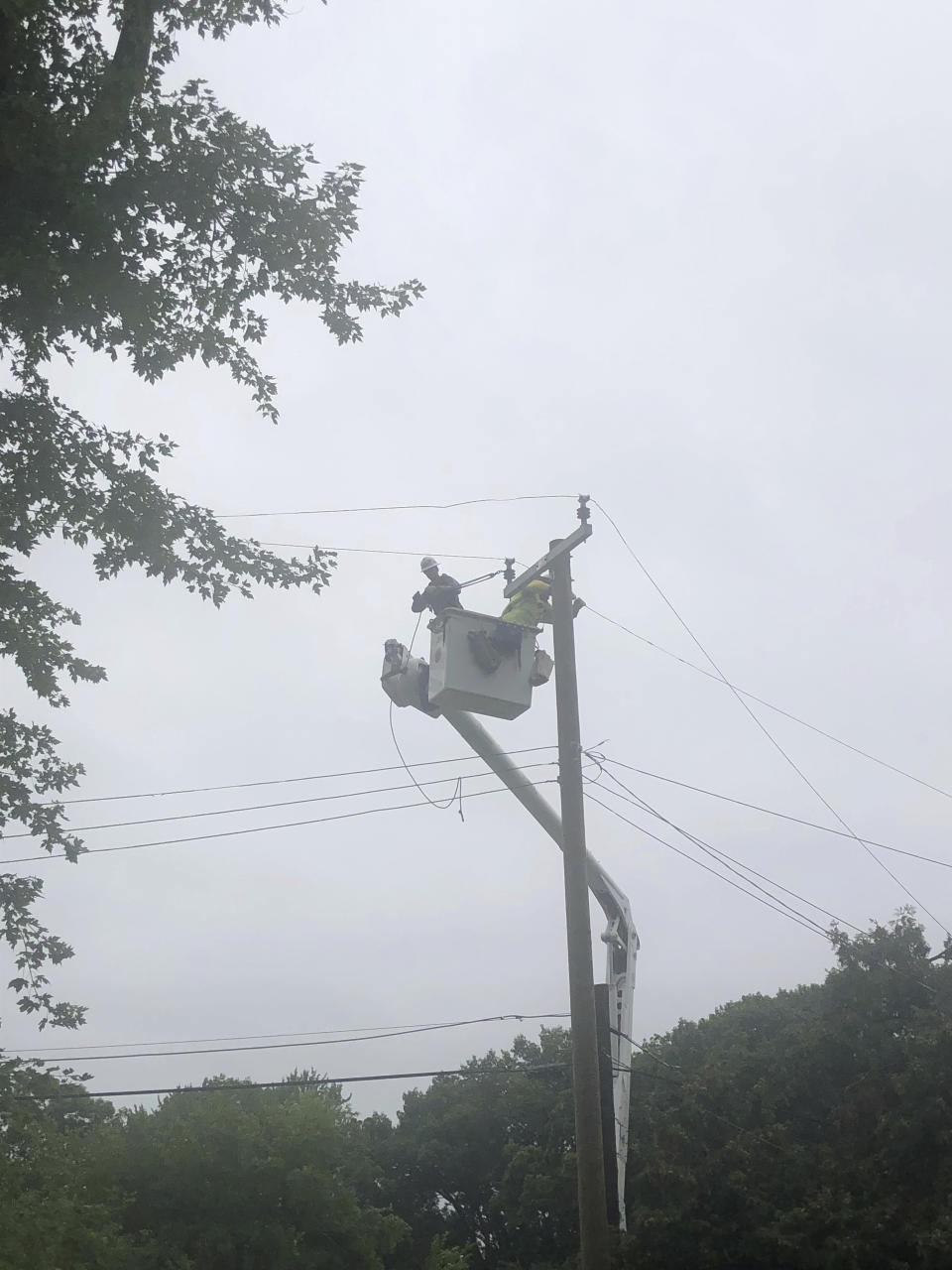 Utility contractors work Friday, Aug. 25, 2023, to repair power lines in Southfield, Mich., north of Detroit. Severe storms powered by winds of up to 75 mph (121 kph) in Michigan downed trees, tore roofs off buildings and killed several people while leaving hundreds of thousands of customers without power, officials said. The National Weather Service said Friday some of the damage may have been caused by two tornadoes. (AP Photo/Corey R. Williams)