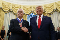 FILE - In this Oct. 24, 2019, file photo, President Donald Trump shakes hands with auto racing great Roger Penske during a Presidential Medal of Freedom ceremony in the Oval Office of the White House. Penske this week celebrated the crowning achievement of a career so rich in America’s fabric that he last month received the Presidential Medal of Freedom by buying iconic Indianapolis Motor Speedway. On Sunday he will watch two of his drivers try to make NASCAR’s championship race. (AP Photo/Alex Brandon, File)
