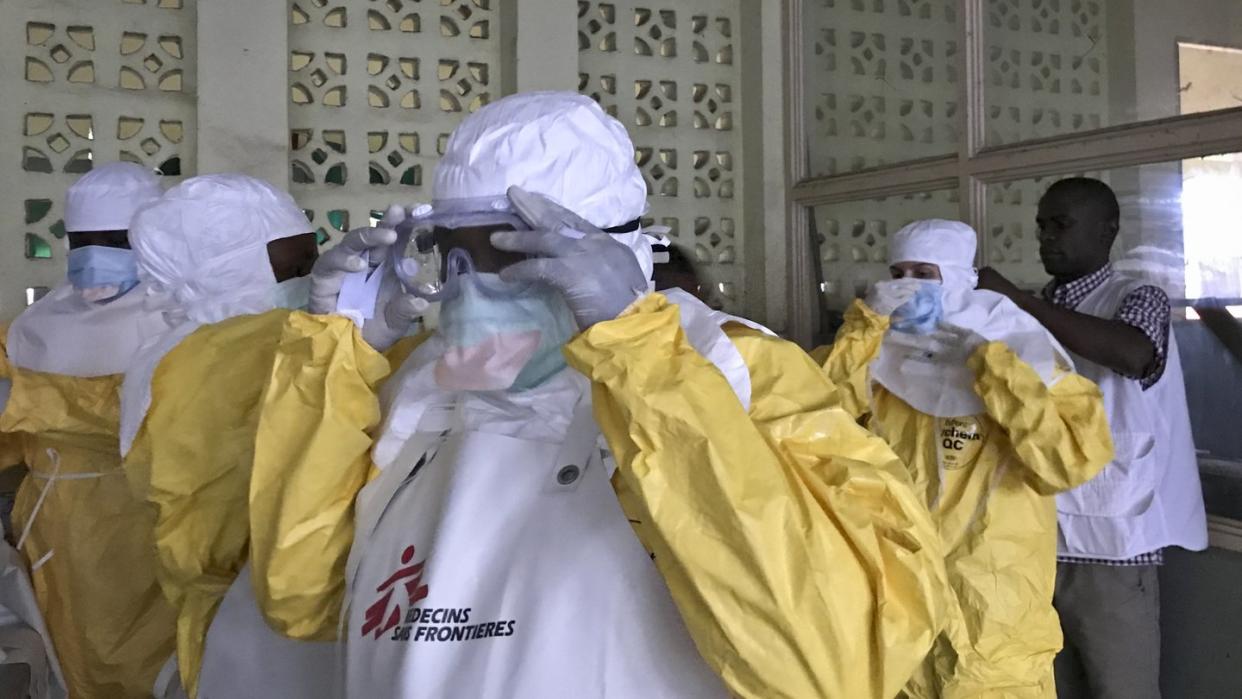 Mitarbeiter von Ärzte ohne Grenzen bereiten sich in Schutzanzügen, darauf vor Ebola-Patienten in einem Krankenhaus in Mbandaka zu behandeln. Foto: Louise Annaud