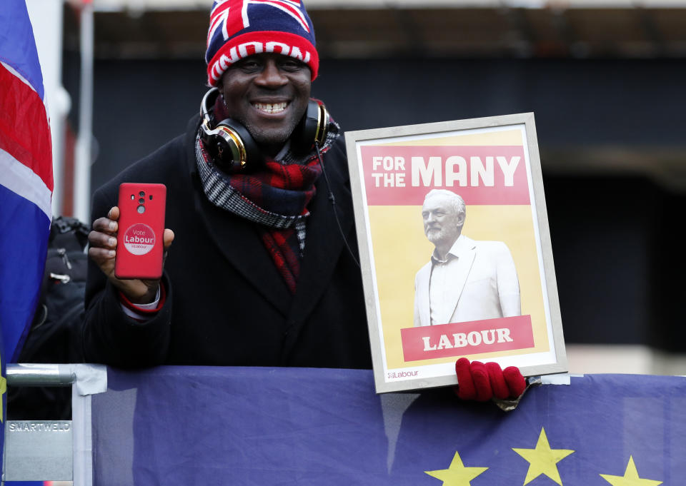 A protester holds a poster depicting Labour party leader Jeremy Corbyn in London, Wednesday, Jan. 16, 2019. British lawmakers overwhelmingly rejected Prime Minister Theresa May's divorce deal with the European Union on Tuesday, plunging the Brexit process into chaos and triggering a no-confidence vote that could topple her government. (AP Photo/Frank Augstein)