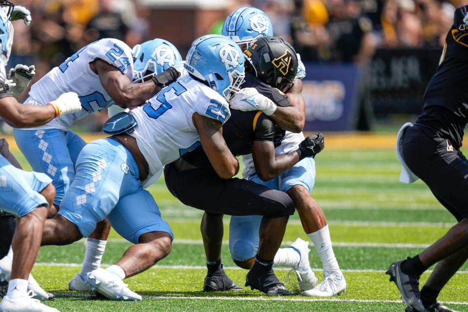 Sep 3, 2022; Boone, North Carolina, USA; Appalachian State Mountaineers running back Nate Noel (5) is gang tackled by UNC defenders during the second half at Kidd Brewer Stadium.