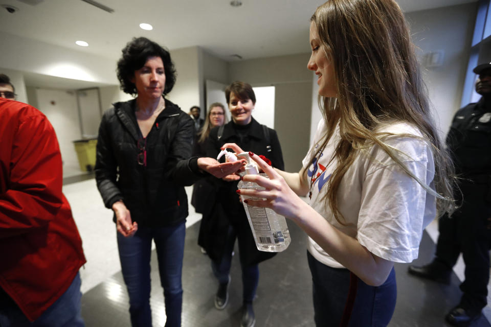 Volunteers supply hand sanitizer before to the public as they enter a campaign rally at Renaissance High School for Democratic presidential candidate former Vice President Joe Biden in Detroit, Monday, March 9, 2020. (AP Photo/Paul Sancya)