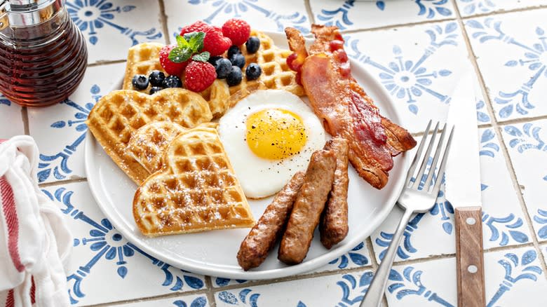 Breakfast with waffles, bacon, sausage