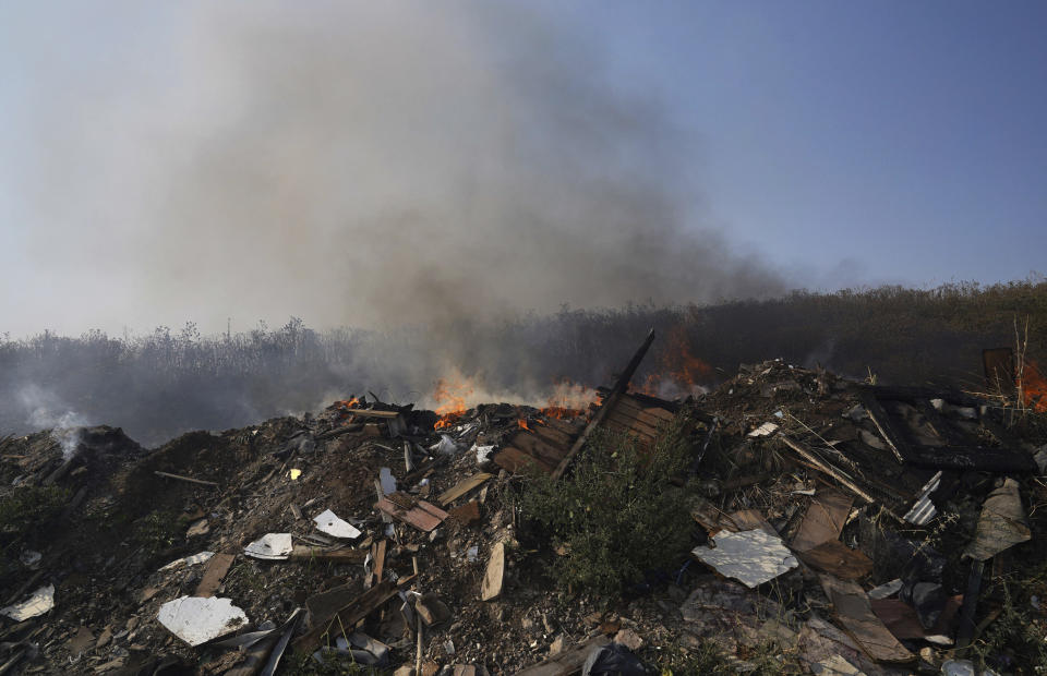 The scene of a blaze is in the village of Wennington, east London, Tuesday, July 19, 2022. The typically temperate nation of England is the latest to be walloped by unusually hot, dry weather that has triggered wildfires from Portugal to the Balkans and led to hundreds of heat-related deaths. (Yui Mok/PA via AP)