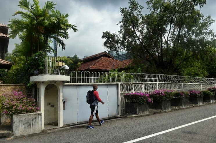 A man walks past 38 Oxley Road, the home for Singapore’s late prime minister Lee Kuan Yew. (PHOTO: AFP)