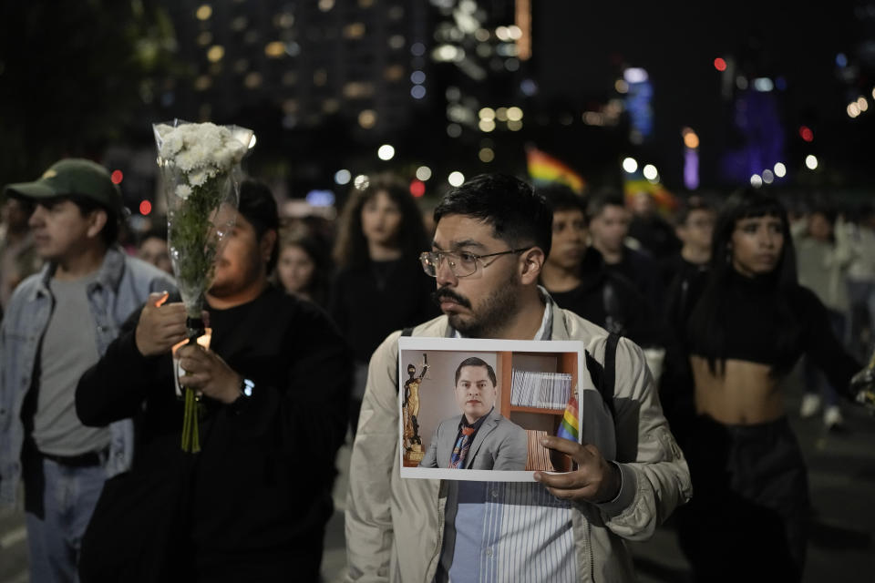 Un manifestante sostiene una fotografía del magistrade del Tribunal Electoral del estado de Aguascalientes Jesús Ociel Baena, durante una vigilia tras su muerte, en la Ciudad de México, el 13 de noviembre de 2023. (AP Foto/Eduardo Verdugo)