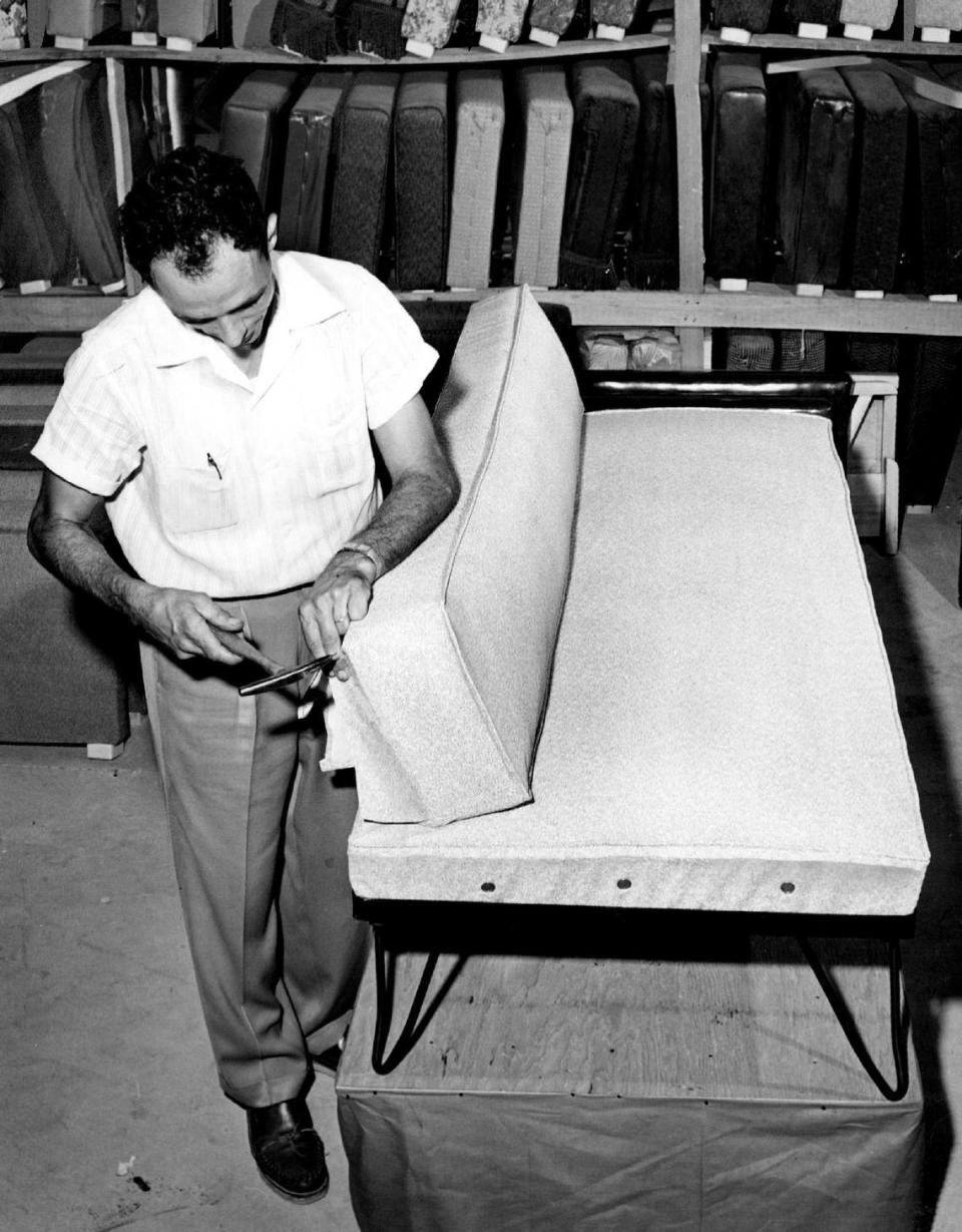 Richard De Maria, de Dixie Bedding Co. en Hialeah, coloca un plástico antimoho en el respaldo de un sofá. La fábrica, iniciada en 1946, está siendo reconvertida en un local de música y arte por la promotora Avra Jain y sus socios.