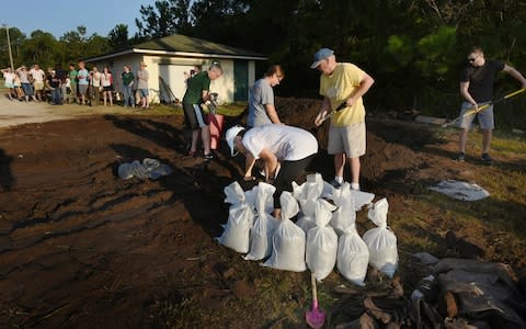 St Johns County Florida residents wait for the arrival of sandbags at Mills Field - Credit:  Bob Self/The Florida Times-Union via AP