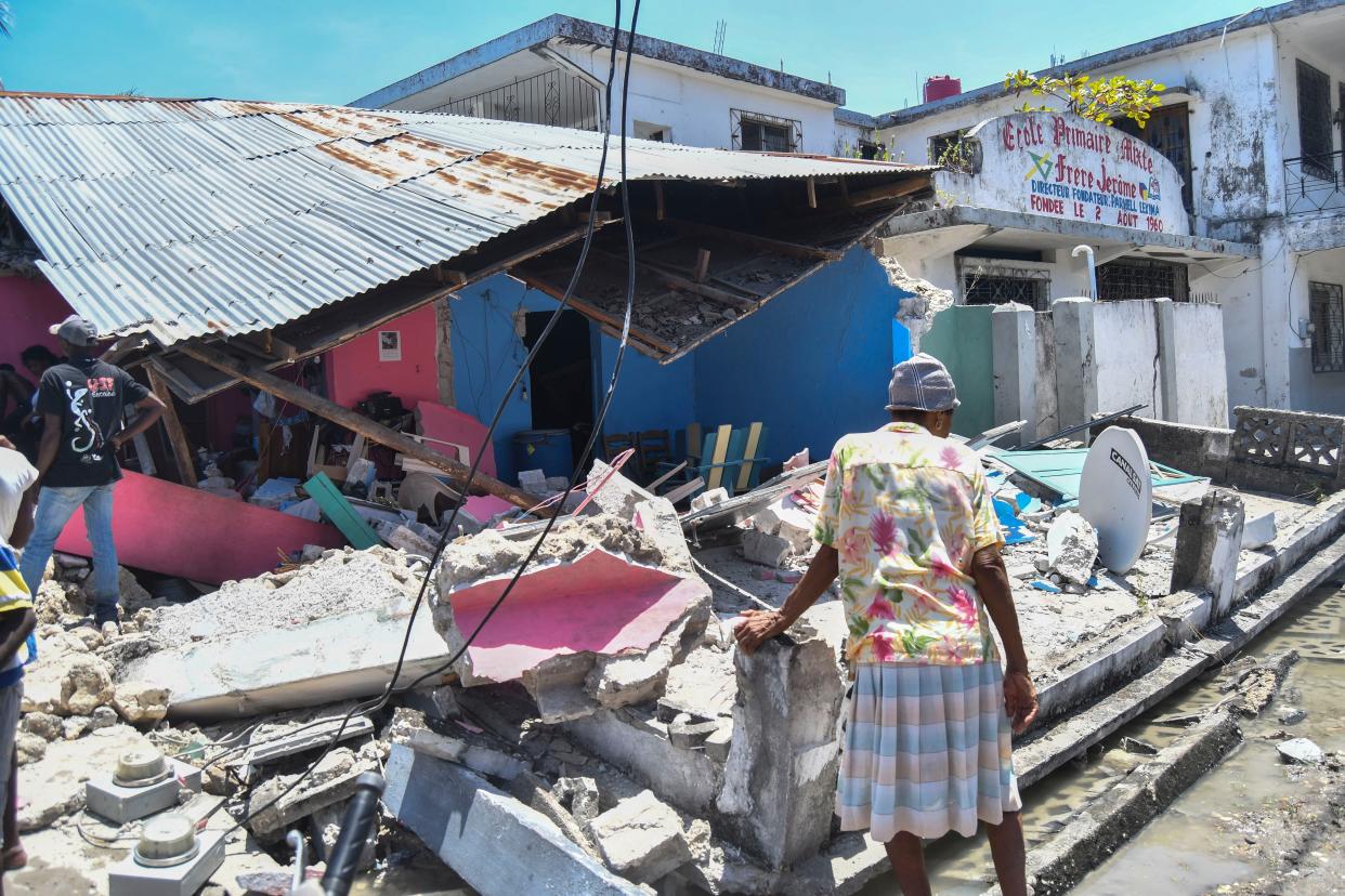 A woman stands in front of a destroyed home in the aftermath of an earthquake in Les Cayes, Haiti, Saturday, Aug. 14, 2021. A 7.2 magnitude earthquake struck Haiti on Saturday, with the epicenter about 125 kilometers (78 miles) west of the capital of Port-au-Prince, the U.S. Geological Survey said.