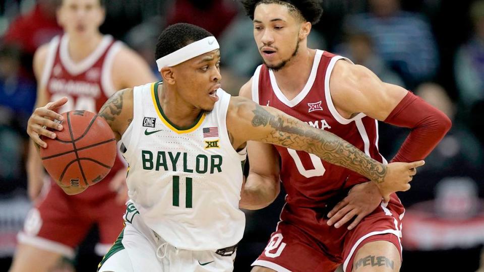 Baylor guard James Akinjo (11) drives past Oklahoma guard Jordan Goldwire (0) during the first half of an NCAA college basketball game in the quarterfinal round of the Big 12 Conference tournament in Kansas City, Mo., Thursday, March 10, 2022. (AP Photo/Charlie Riedel)