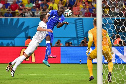 Italy's forward Mario Balotelli (C) heads the ball to score a goal during a World Cup Group D football match against England at the Amazonia Arena in Manaus on June 14, 2014