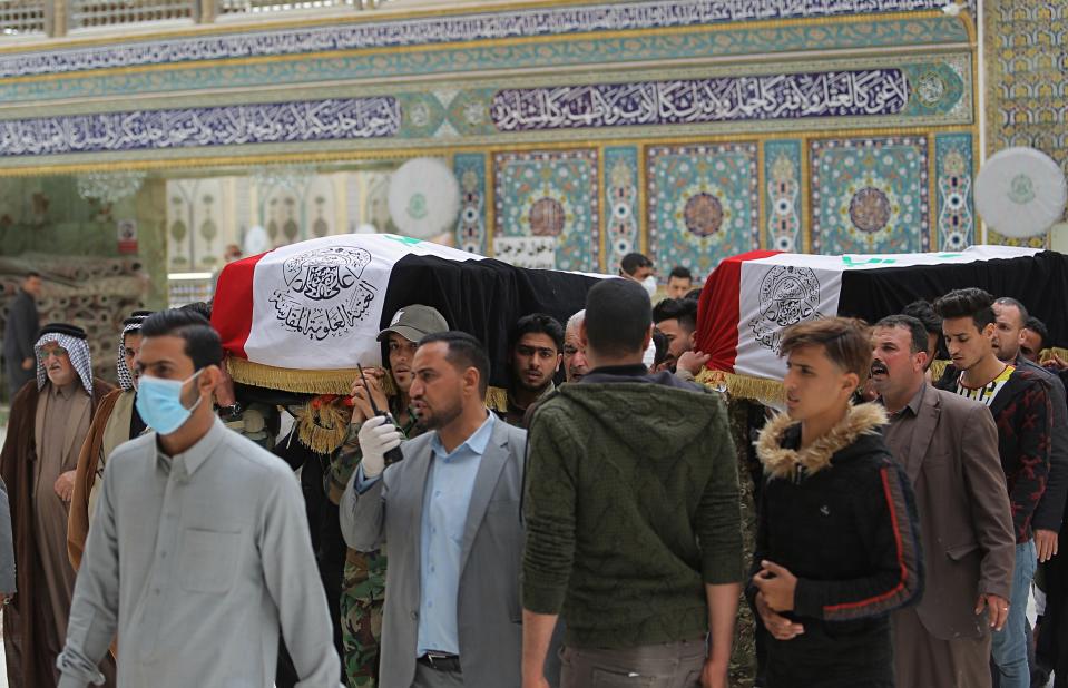 Mourners carry the flag-draped coffins of two fighters of the Popular Mobilization Forces who were killed during the US attack against militants in Iraq, during their funeral procession at the Imam Ali shrine in Najaf, Iraq, Saturday, March 14, 2020. The U.S. launched airstrikes on Thursday in Iraq, targeting the Iranian-backed Shiite militia members believed responsible for a rocket attack that killed and wounded American and British troops at a base north of Baghdad. (AP Photo/Anmar Khalil)