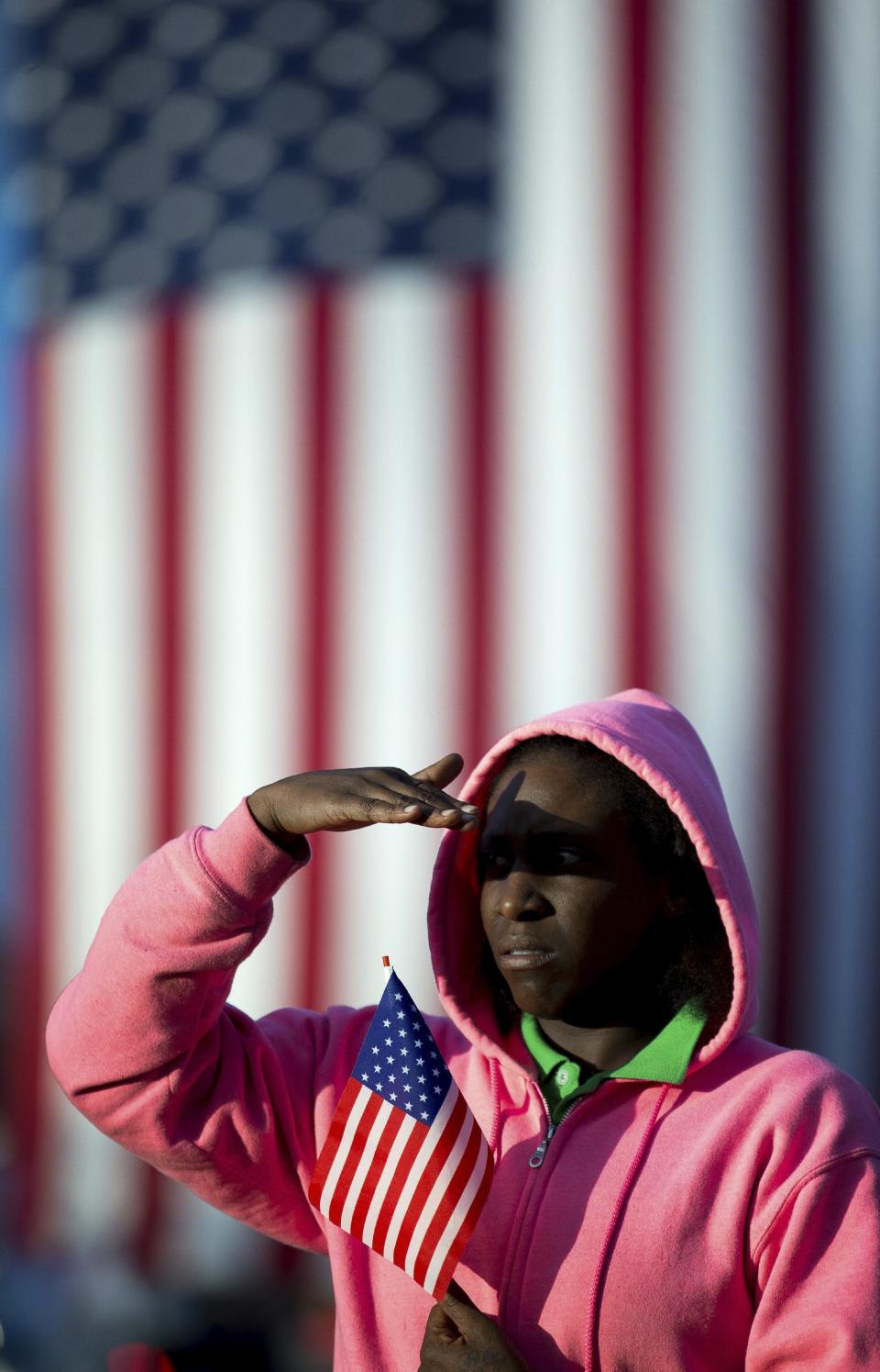 Felicia Walker watches the funeral of Americus Police Officer Nicholas Smarr across the street from Oak Grove Cemetery, Sunday, Dec. 11, 2016, in Americus, Ga. Smarr and his lifelong friend, Georgia Southwestern State University campus police officer Jody Smith, were killed responding to a domestic violence call on Wednesday. (AP Photo/Branden Camp)