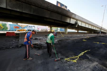 Municipal workers sweeps the ground at the site of a suicide bomb attack at Nakheel Mall across from the oil ministry, in Baghdad, in Iraq September 10, 2016. REUTERS/Khalid al Mousily