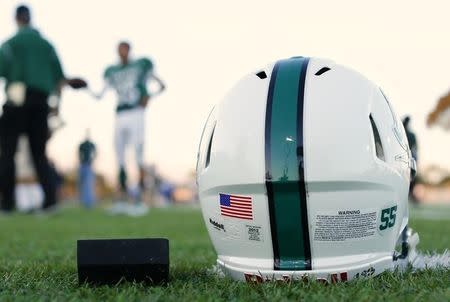 A football helmet's health warning sticker is pictured at a high school football team practice in Oceanside, California September 14, 2012. REUTERS/Mike Blake