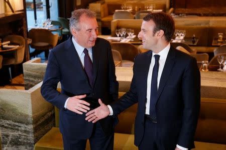 Emmanuel Macron, (R) head of the political movement En Marche !, or Onwards !, candidate for the 2017 presidential election, and Francois Bayrou, French centrist politician and the leader of the Democratic Movement (MoDem), arrive for a news conference after sealing their alliance for the presidential campaign, in Paris, France, February 23, 2017. REUTERS/Charles Platiau