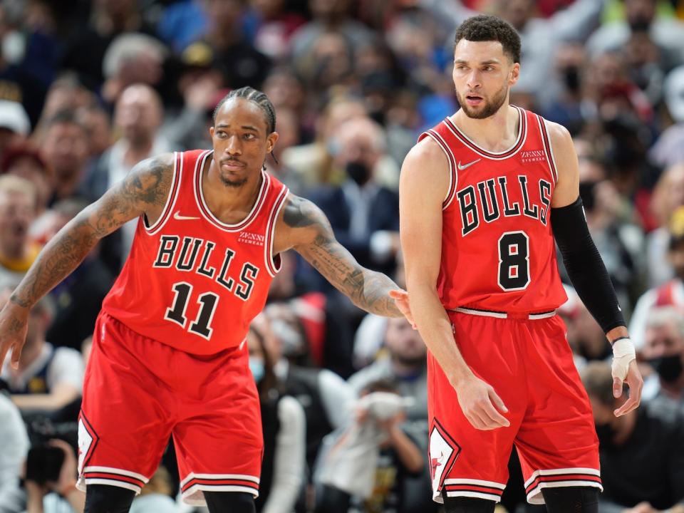 DeMar DeRozan taps Zach LaVine as the two stand on the court next to each other in 2021.