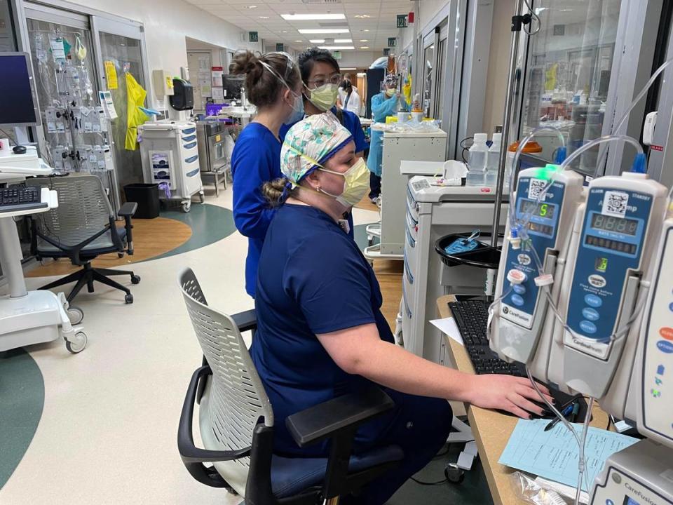 Novant Health ICU team members gather outside a patient’s room to discuss the patient’s progress and treatment options.