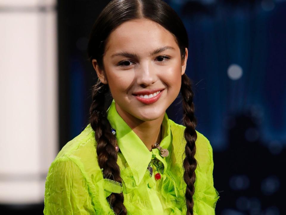 Olivia Rodrigo wearing a bright green blouse and her hair in two braids during an appearance on "Jimmy Kimmel Live" in October 2021.