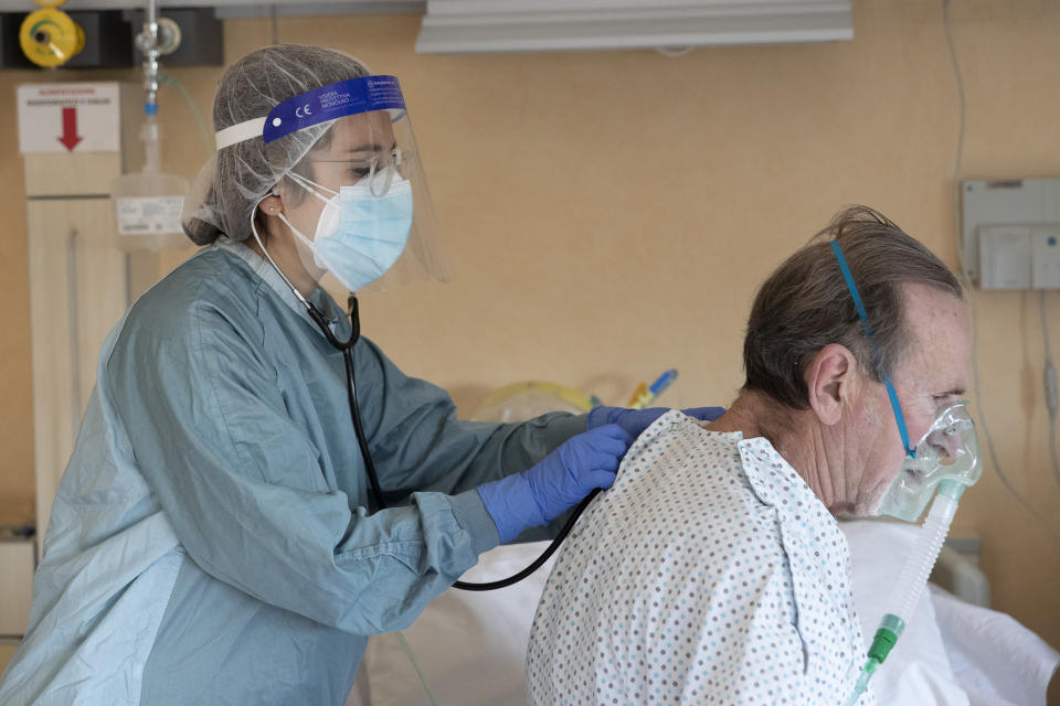 Dr. Elisabetta Teti visits COVID-19 patient 67-year-old Roberto Tortosa, in a sub-intensive COVID-19 unit of the Tor Vergata Polyclinic Hospital, in Rome, Saturday, Nov. 7, 2020. (AP Photo/Alessandra Tarantino)