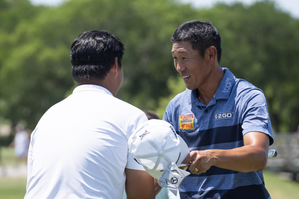 James Hahn, right, shakes hands with Joohyung Kim, left, of South Korea, after completing the third round of the AT&T Byron Nelson golf tournament in McKinney, Texas, on Saturday, May 14, 2022. (AP Photo/Emil Lippe)