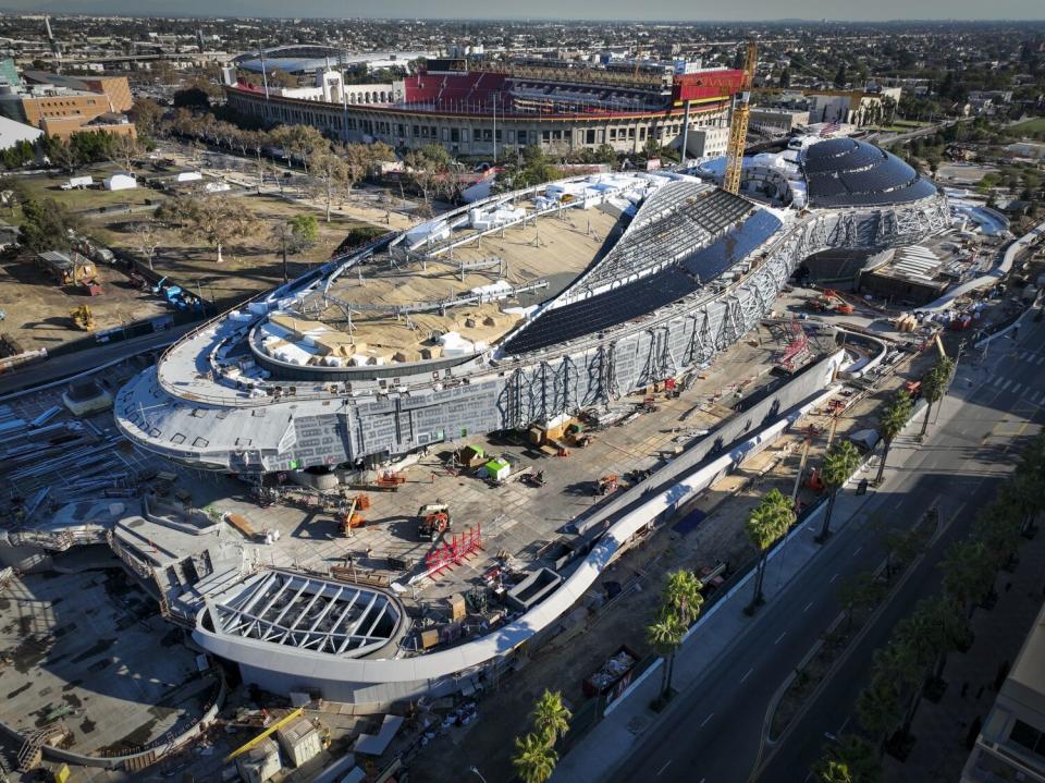 The L.A. Coliseum stands behind the Lucas Museum of Narrative Art under construction in Exposition Park.