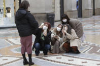 Tourists, wearing face masks, pose for a selfie in downtown Milan, Italy, Thursday, Feb. 27, 2020. In Europe, an expanding cluster in northern Italy is eyed as a source for transmissions of the COVID-19 disease. (AP Photo/Luca Bruno)