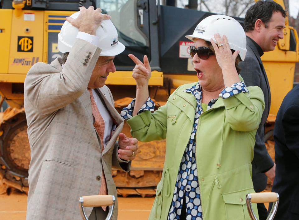 Nick Saban smiles as his wife Terry reacts to him putting on a construction hard hat before the groundbreaking for the Saban Catholic Student Center on Feb. 1, 2016.