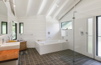 <p>The large bathroom is spacious and features a stand alone bathtub and large walk-in shower.</p>