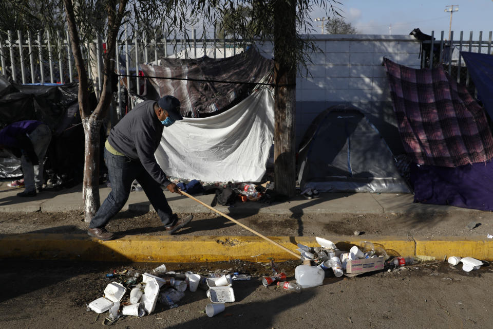 Robin Ortega, a Mexican migrant from Puebla who joined a caravan of Central Americans, cleans up trash outside an overflowing sports complex where more than 5,000 migrants are sheltering, in Tijuana, Mexico, Wednesday, Nov. 28, 2018. "It's one thing to be poor. It's another to be filthy," says Ortega, who left his job as a heavy machinery driver in hopes of finding better work that will pay for his two children to finish college. (AP Photo/Rebecca Blackwell)