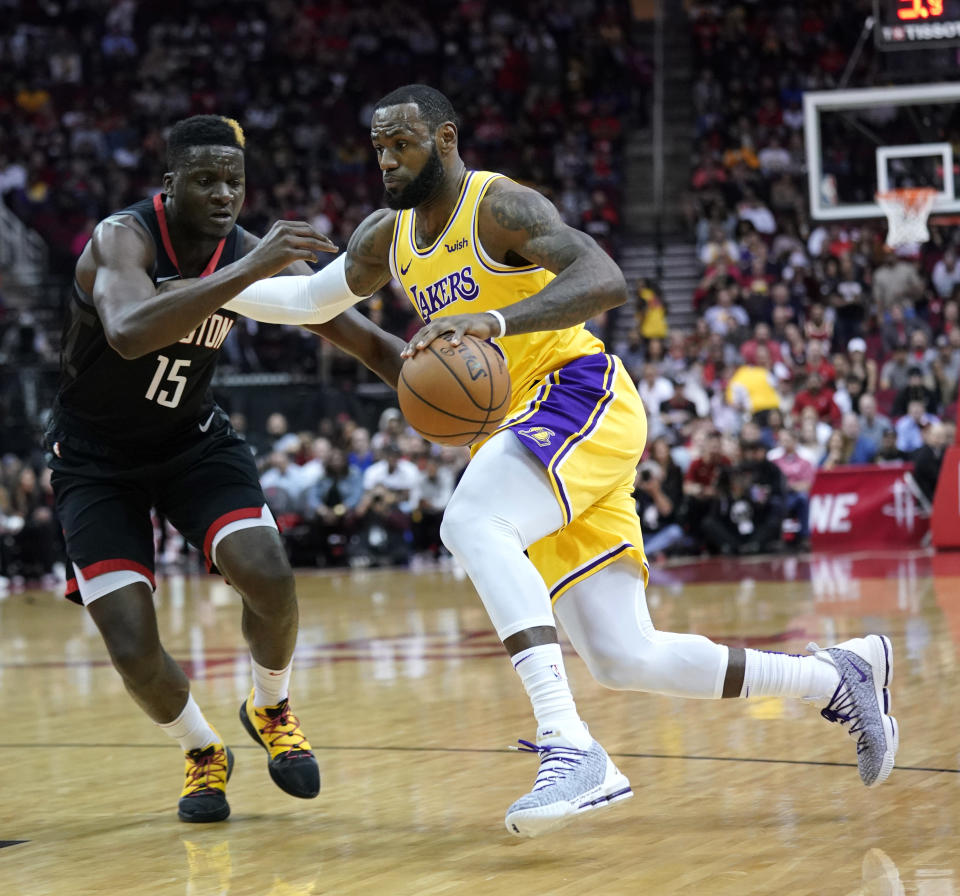 Los Angeles Lakers' LeBron James, right, drives toward the basket as Houston Rockets' Clint Capela (15) defends during the first half of an NBA basketball game Thursday, Dec. 13, 2018, in Houston. (AP Photo/David J. Phillip)