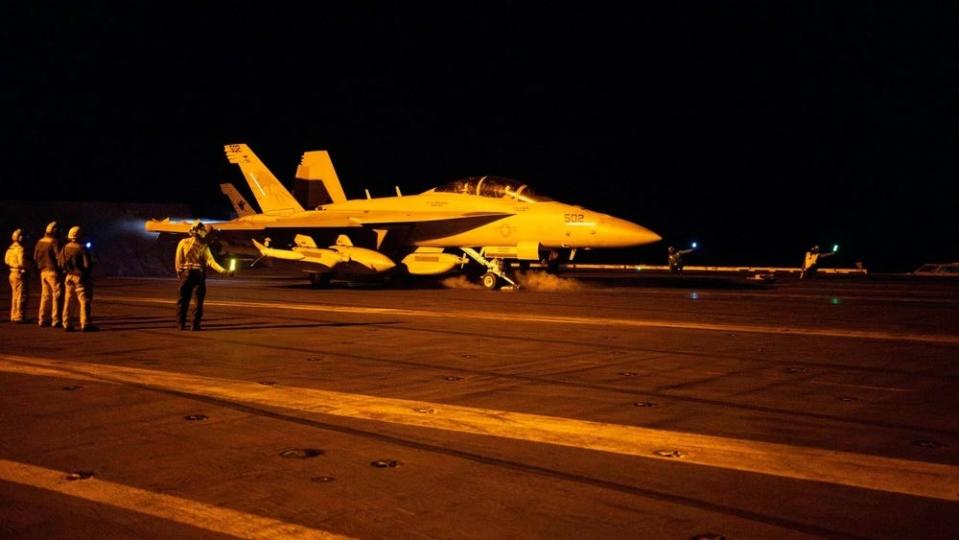 an aircraft on the flight deck of a military carrier