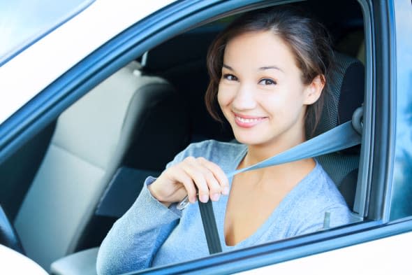 smiling young woman in car...