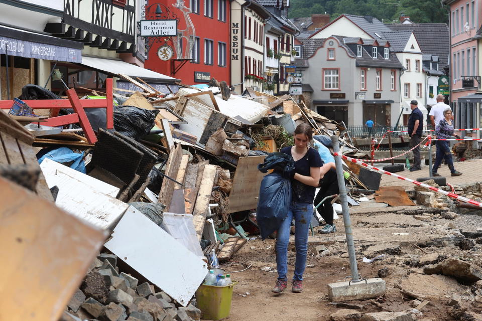 A woman carries a bag in an area affected by floods caused by heavy rainfalls in Bad Muenstereifel, Germany, July 19, 2021. / Credit: WOLFGANG RATTAY/REUTERS