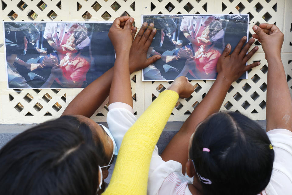 Varias personas colocan fotos de Mya Thwet Thwet Khine en una pared durante un homenaje en Mandalay, Myanmar, el 19 de febrero de 2021. (AP Foto)