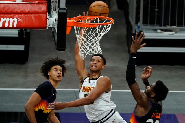 Denver Nuggets centre Isaiah Hartenstein (25) shoots between Phoenix Suns’ Cameron Johnson and Deandre Ayton (22)