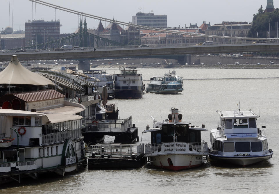 In this photo taken on Wednesday, June 5, 2019, restaurant and tour boats are docked on the Danube River near the Elizabeth Bridge in Budapest. A tourism boom in the Hungarian capital has led to major congestion on the river flowing through the city, with sightseeing boats and floating hotels competing for better positions in front of spectacular neo-Gothic buildings, ornate bridges and churches lining the Danube. (AP Photo/Laszlo Balogh)