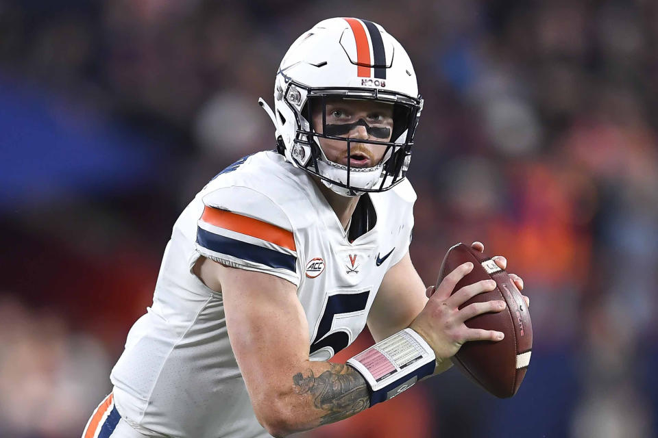 FILE - Virginia quarterback Brennan Armstrong (5) runs with the ball during the second half of an NCAA college football game against Syracuse, Sept. 23, 2022, in Syracuse, N.Y. N.C. State opens the season at Connecticut on Aug. 31, 2023. (AP Photo/Adrian Kraus, File)