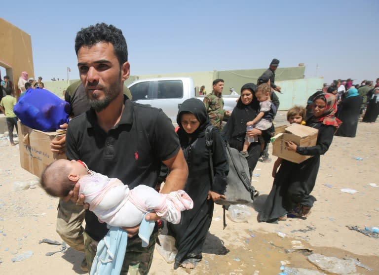 Iraqi families arrive at a camp for displaced people in the district of Hajaj after fleeing the towns of al-Shirqat and Qayyarah, south of Mosul, on July 27, 2016