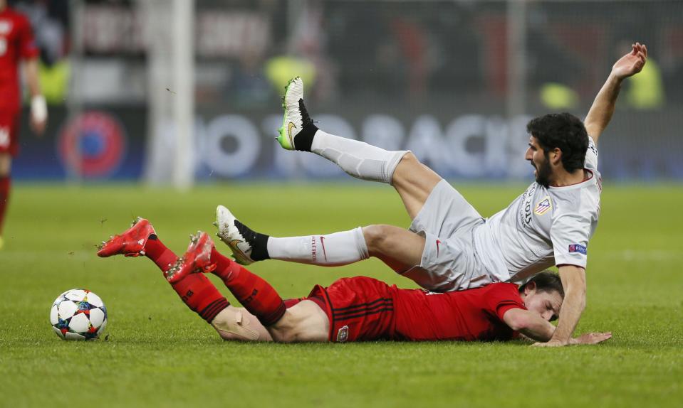 Bayer Leverkusen's Lars Bender collides with Atletico Madrid's Raul Garcia (top) during their Champions League round of 16, first leg soccer match in Leverkusen February 25, 2015. REUTERS/Wolfgang Rattay (GERMANY - Tags: SPORT SOCCER)