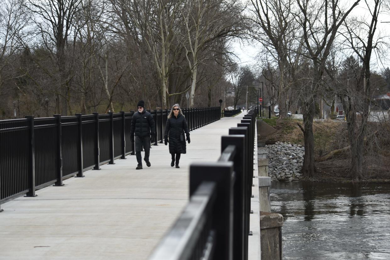 Chris Vandenbossche, left, and Laura Haigwood walk across a newly opened pedestrian bridge on the Stephen J. Luecke Coal Line Trail. Up to about 30 years ago, trains used to cross the bridge carrying coal to power the campus of the University of Notre Dame.