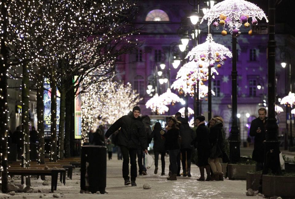 People walk under light decorations during the annual illumination of Christmas lights at Krakowskie Przedmiescie street, part of the historical Trakt Krolewski (The Royal Route), in Warsaw December 7, 2013. REUTERS/Kacper Pempel (POLAND - Tags: SOCIETY)