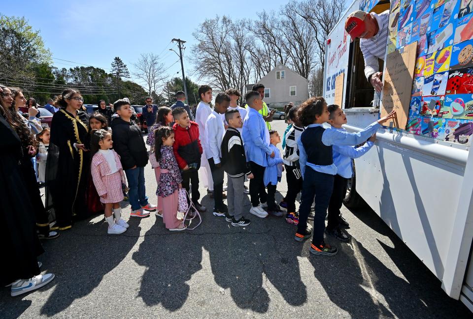 Young Muslims line up for ice cream during the Eid al-Fitr celebration at the Worcester Islamic Center on Friday.