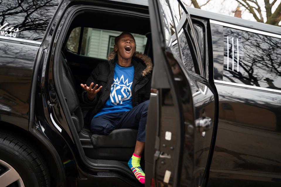 Fifth grader Kenyon Sims, 11, who was diagnosed with osteosarcoma bone cancer in 2020, sings a high note with excitement while sitting in a limousine after attending a school assembly to celebrate his birthday at Detroit Premier Academy in Detroit on Monday, Dec. 5, 2022.