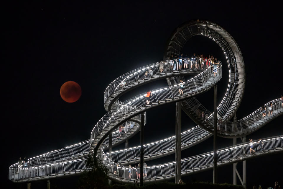 <p>The full moon can be seen behind the landmark “Tiger and Turtle” sculpture and walkway during a “blood moon” eclipse over Duisburg, western Germany, on July 27, 2018. (Photo: Christoph Reichwein/ dpa /AFP/Getty Images) </p>