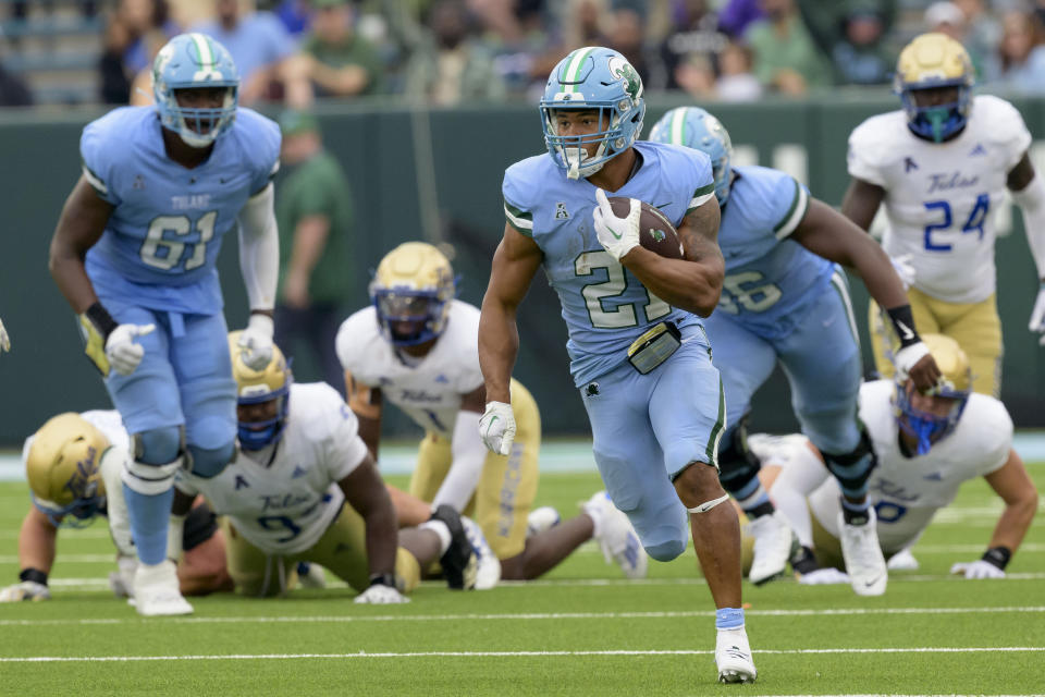 Tulane running back Makhi Hughes (21) breaks free for a long run during the fourth quarter before sliding to keep the ball in Tulane's possession to run out the clock for a win over Tulsa during an NCAA college football game in New Orleans, Saturday, Nov. 11, 2023. (AP Photo/Matthew Hinton)