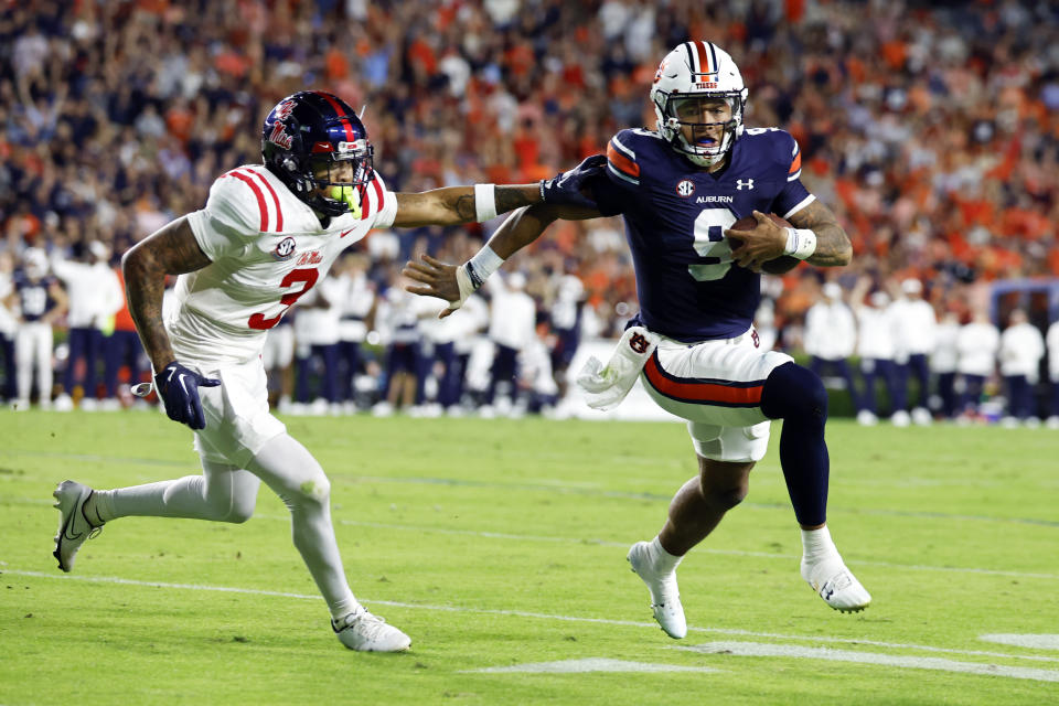 Auburn quarterback Robby Ashford (9) carries the ball as Mississippi safety Daijahn Anthony (3) defends during the first half of an NCAA college football game, Saturday, Oct. 21, 2023, in Auburn, Ala. (AP Photo/ Butch Dill )